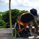 Construction workers wearing complete PPE including hard hats, safety vests, and protective eyewear at job site