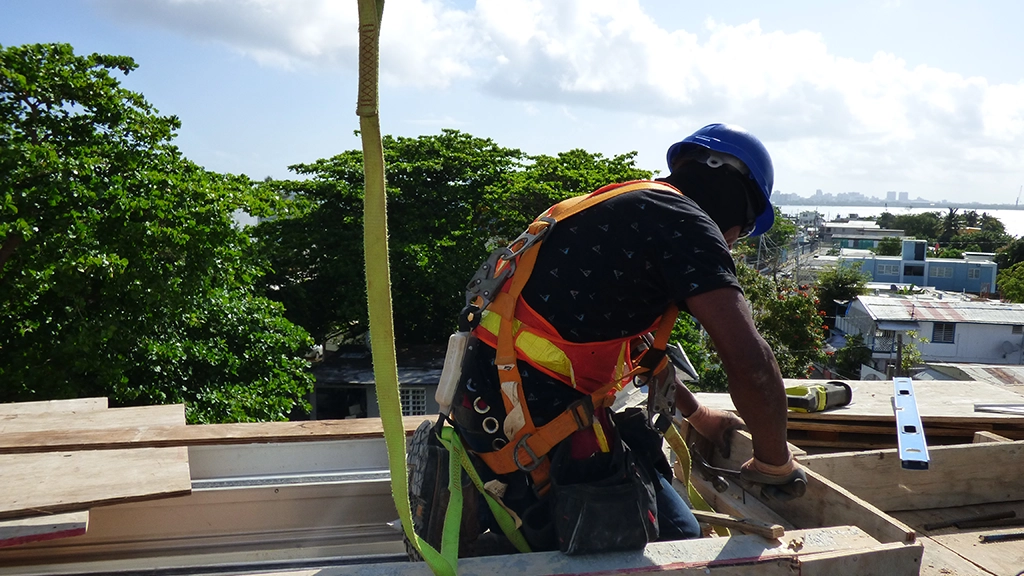 Construction workers wearing complete PPE including hard hats, safety vests, and protective eyewear at job site
